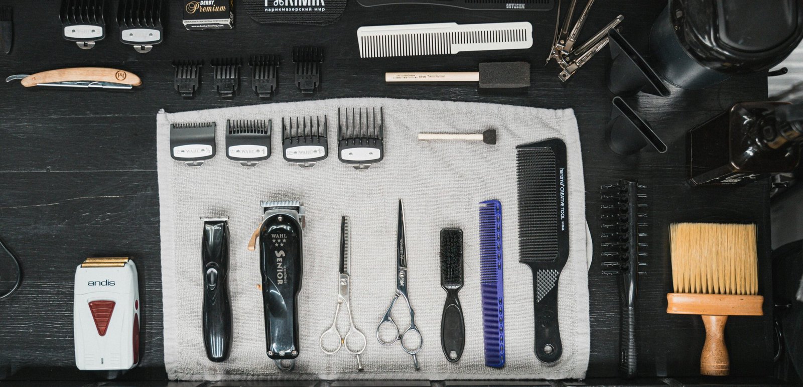 Professional hairdressing tools meticulously arranged in a flat lay, showcasing combs, clippers, scissors, and more.