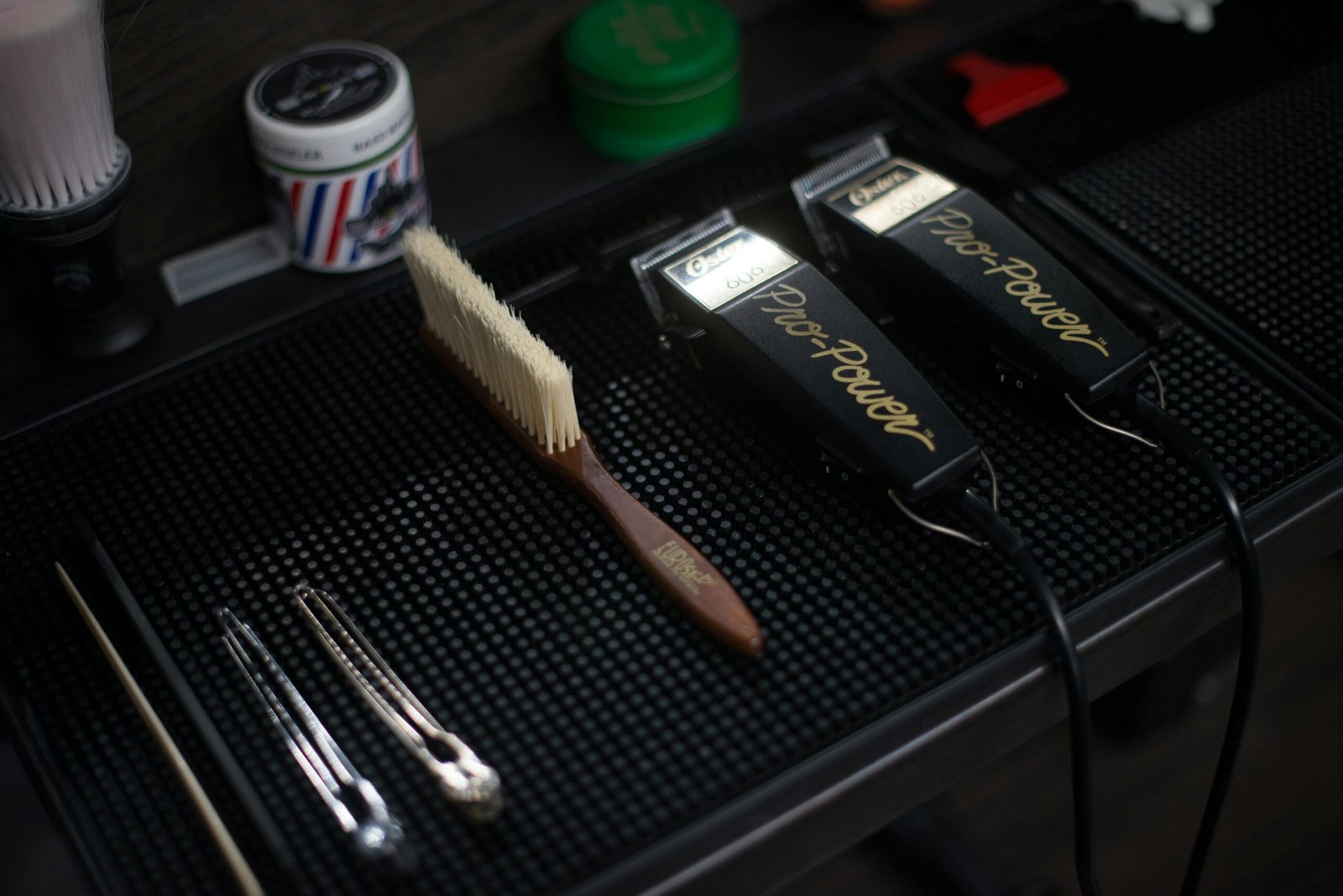 Close-up of hair clippers and grooming tools in a modern barbershop setup.