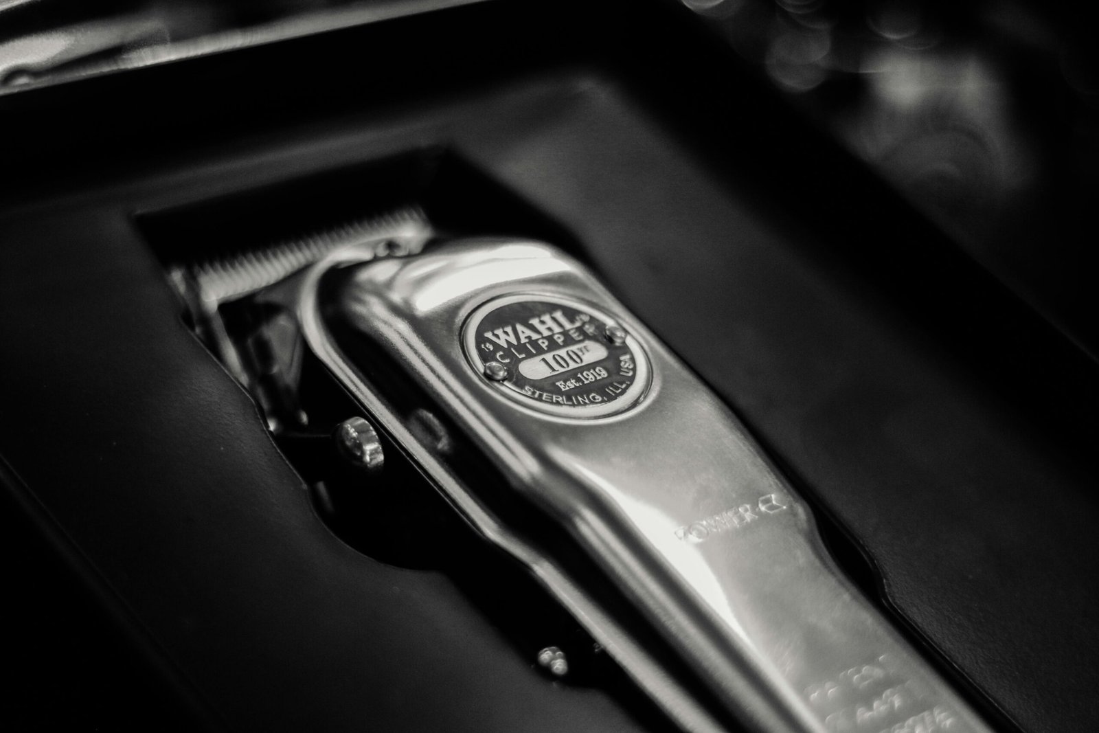 A detailed close-up of a shiny metal cordless clipper in its box, highlighting the sleek design.